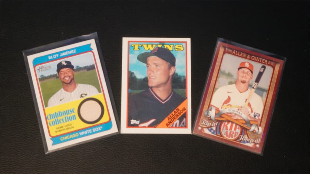 3 baseball cards, outside two have card sleeves, middle does not