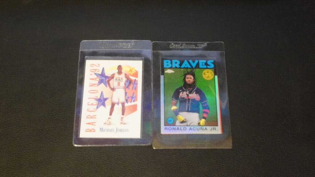 two sports cards inside card savers on a black background